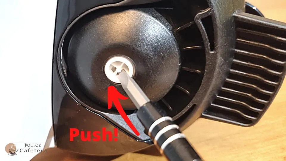 Push the pod with a screw driver