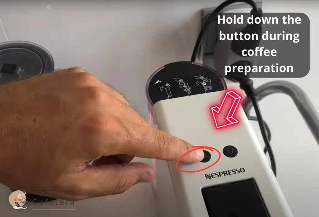 Showing how to hold the button during coffee preparation